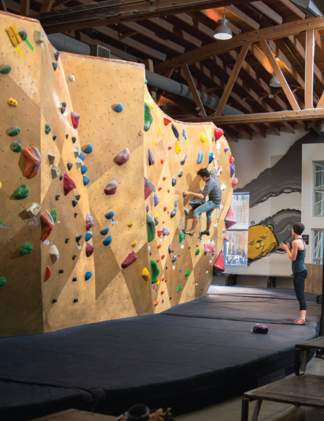 Instructor teaching man how to rock climb