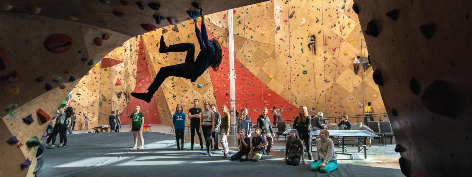 Group of students watching their instructor rock climb