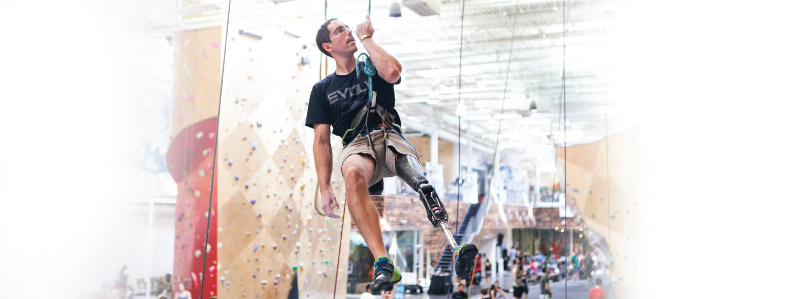 Man with prosthetic leg indoor rock climbing